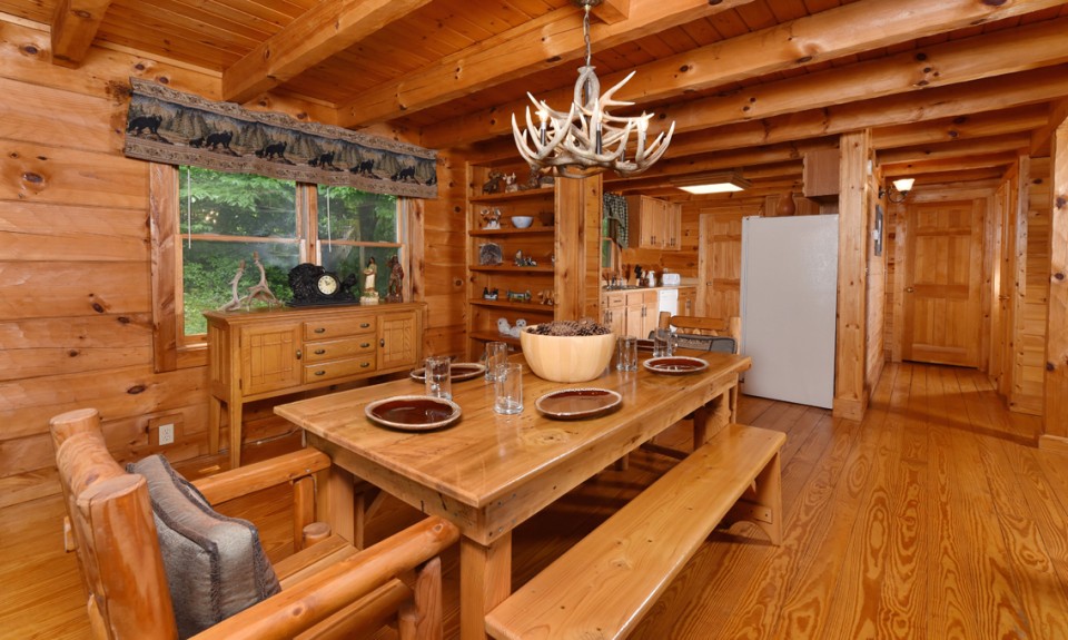 Wooden kitchen in log cabin with a big dining table and benches