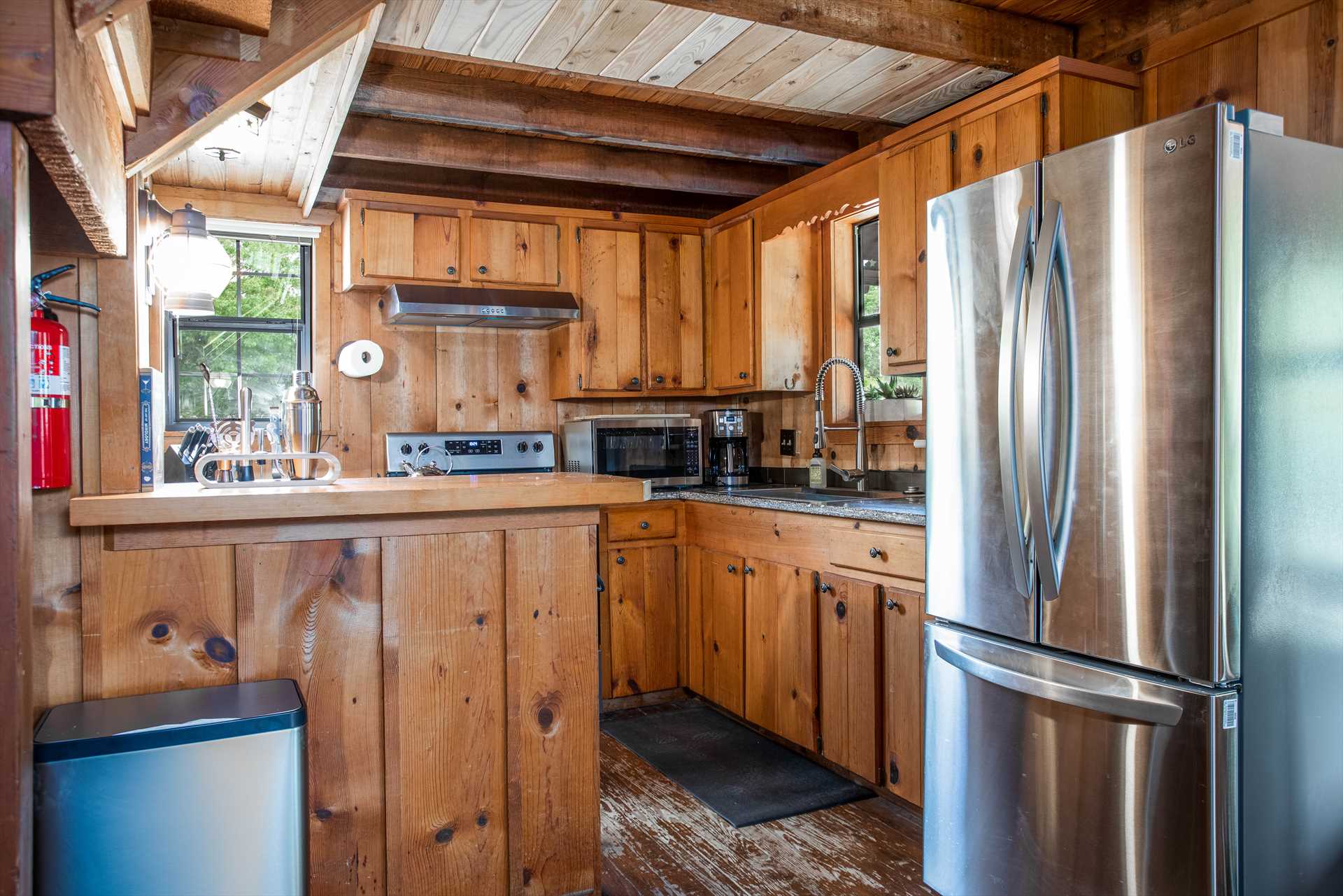 wooden kitchen in cabin with stainless steel appliances