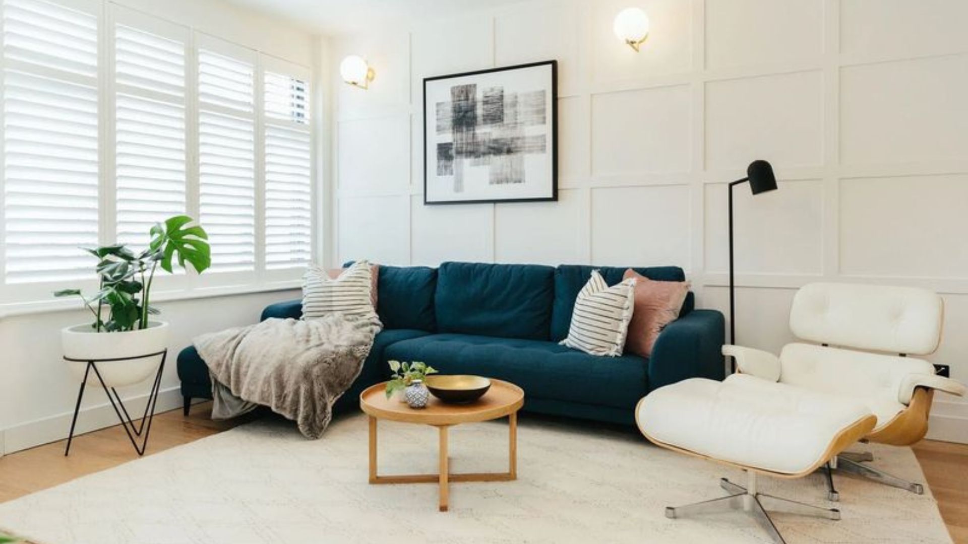 living room with a blue couch, white walls and a round table