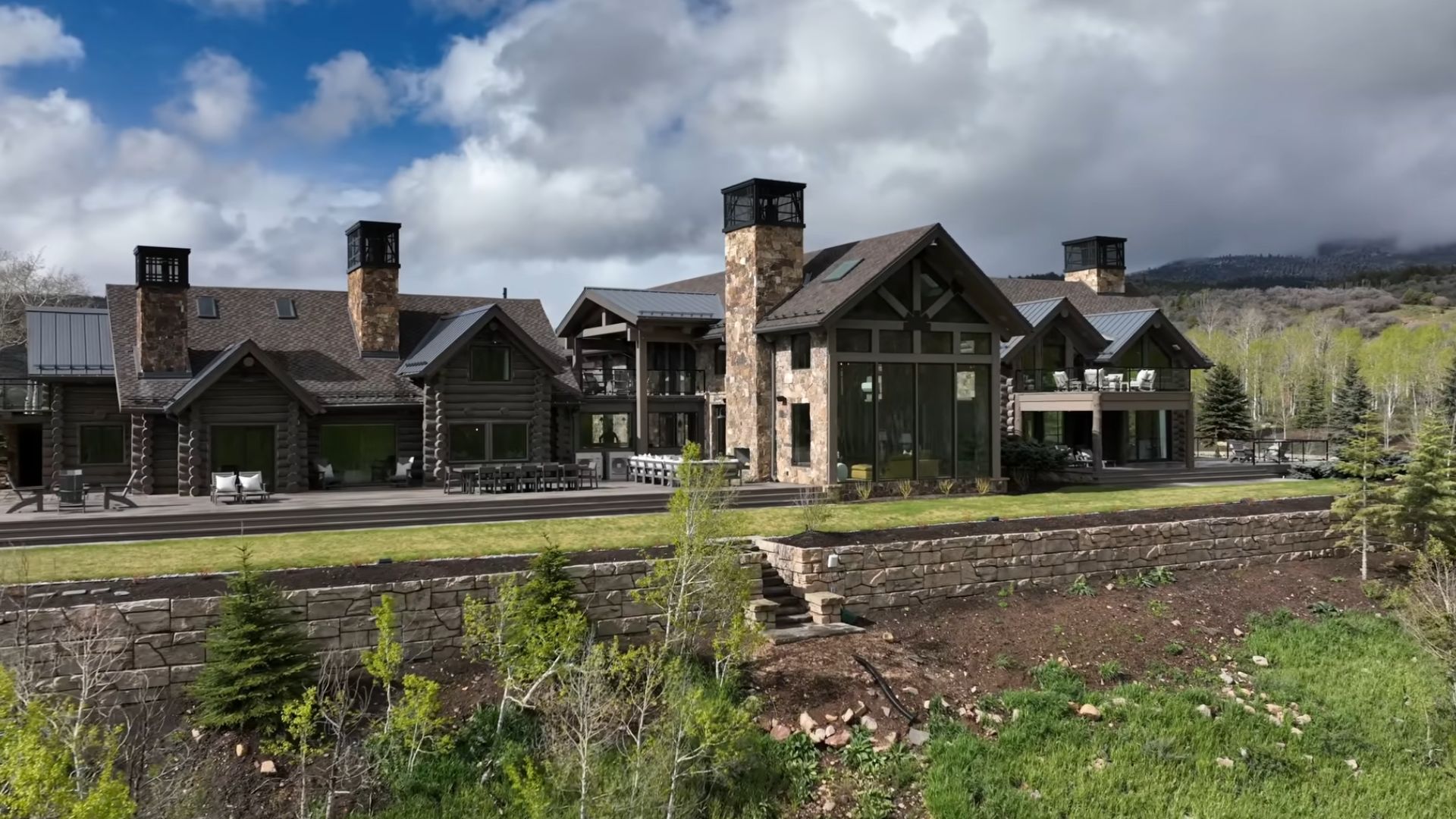 exterior of a big rustic cabin surrounded by a lot of land