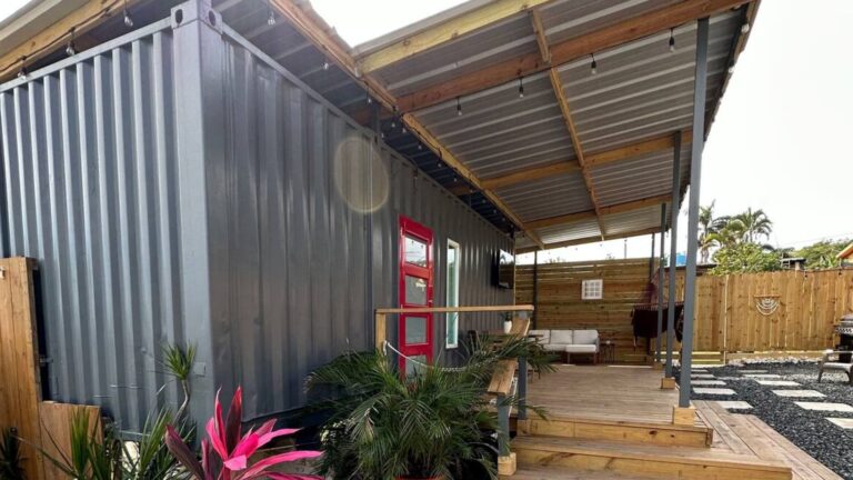 exterior of a container house with a small porch and a yard