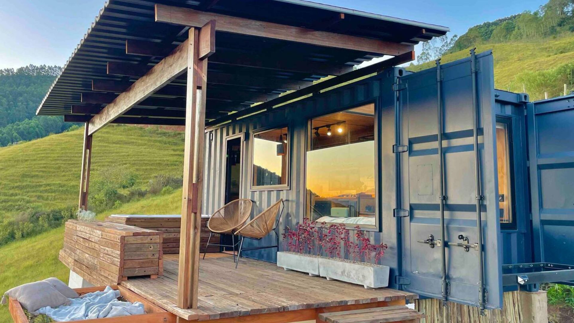 exterior of a container house surrounded by green hills