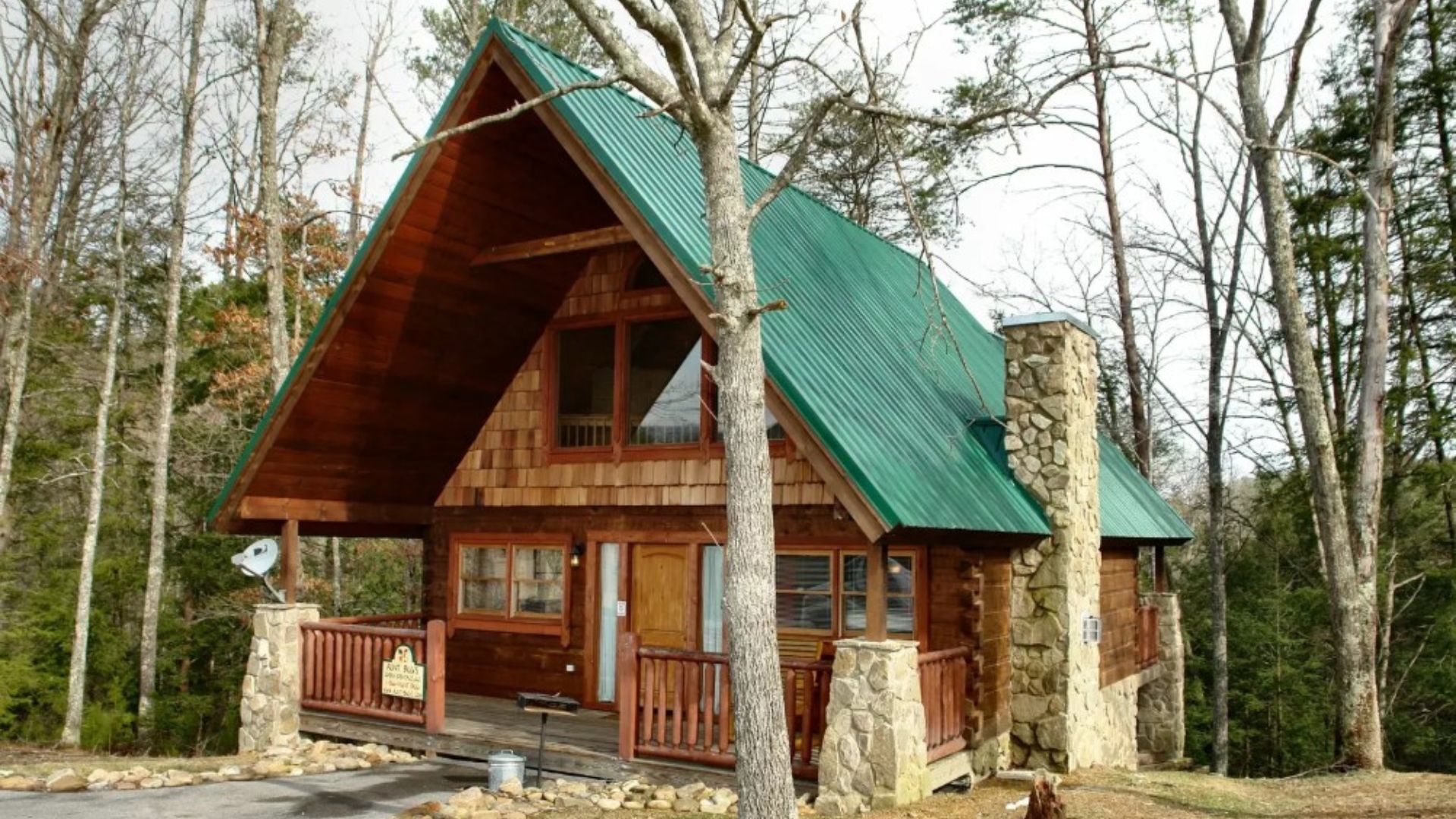 exterior of a wooden cabin surrounded by tall trees