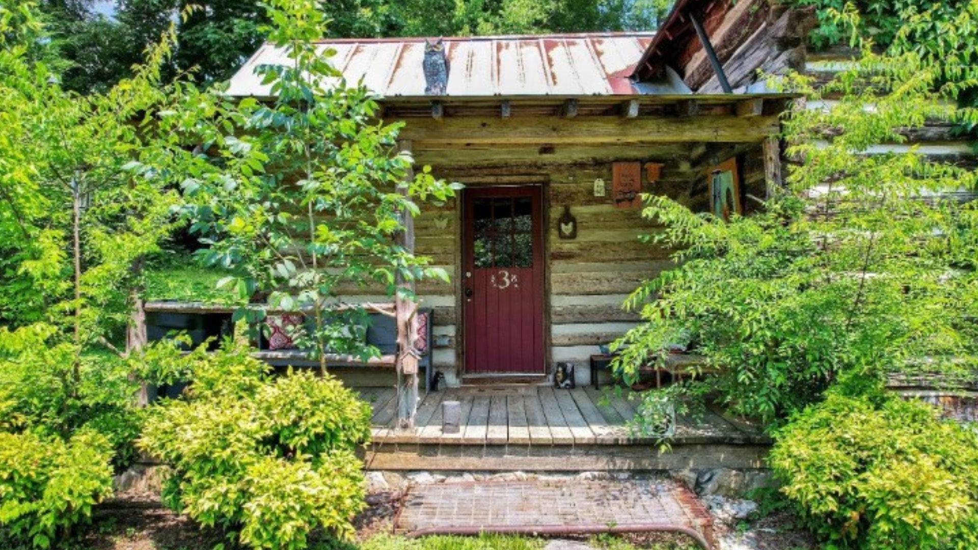 exterior of an old cabin, trees and grass around