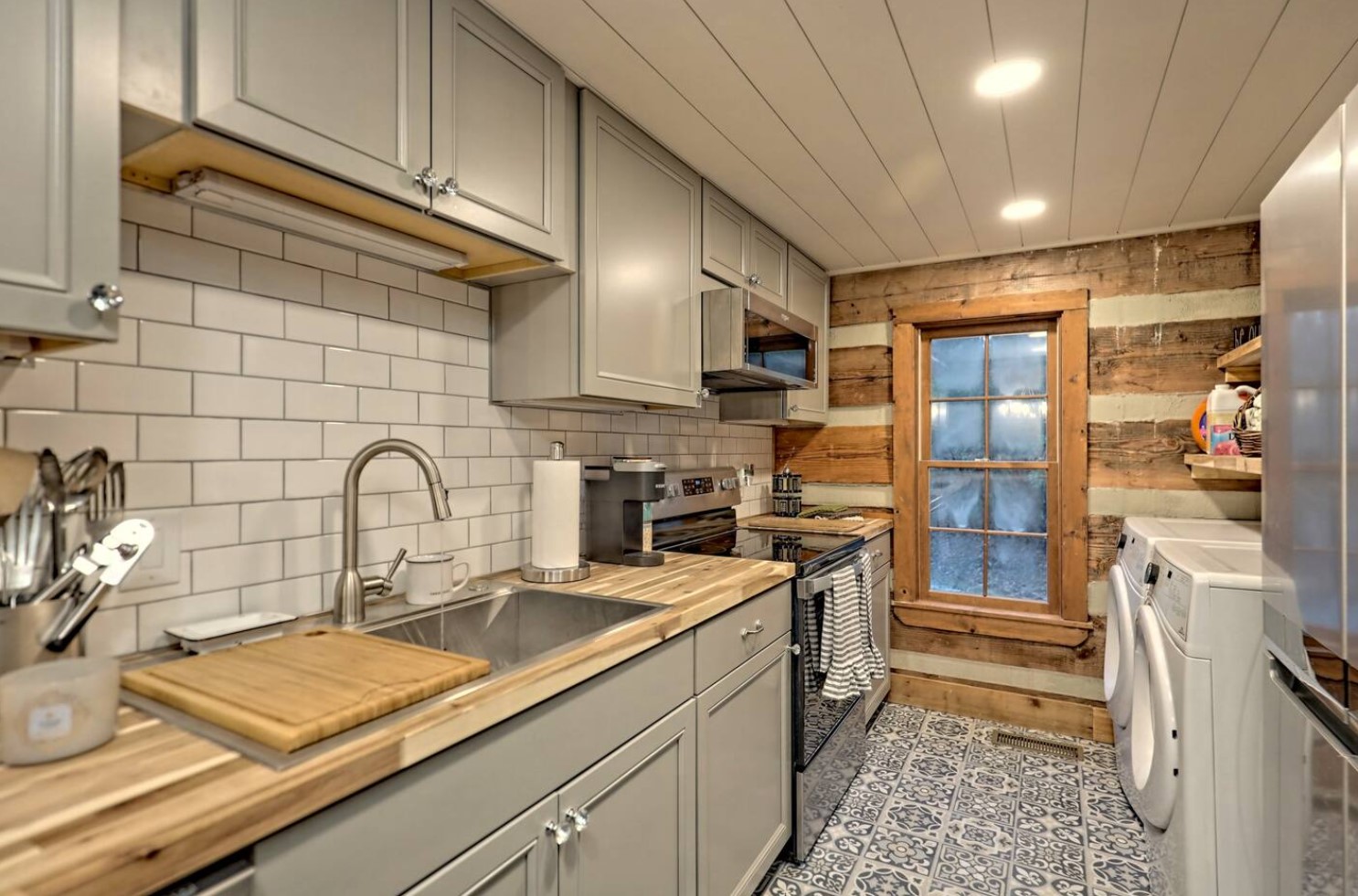 Gray kitchen with stainless steel appliances and laundry room