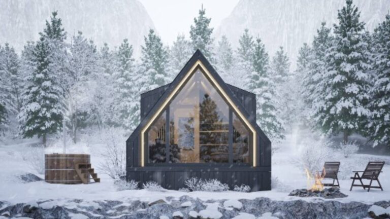 exterior of an a-frame tiny home with chairs in front surrounding a fire pit, winter time