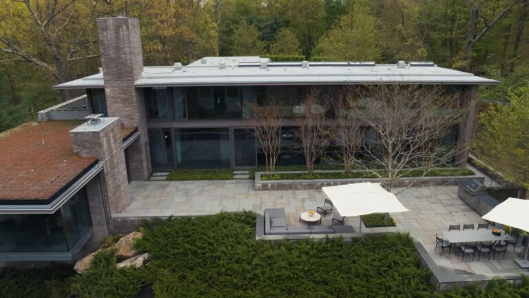 aerial photo of the bold mansion with glass walls built as a cascade on an old and abandoned quarry