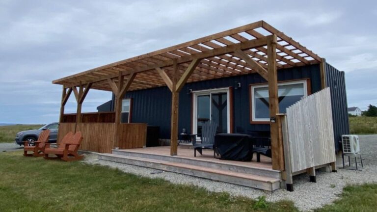 exterior of a container home with black walls and large windows