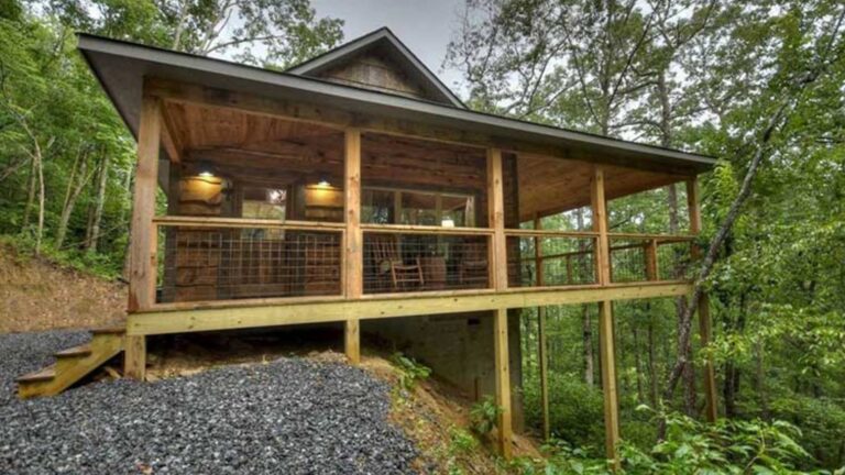 exterior of a cabin in the woods with a wrap around porch