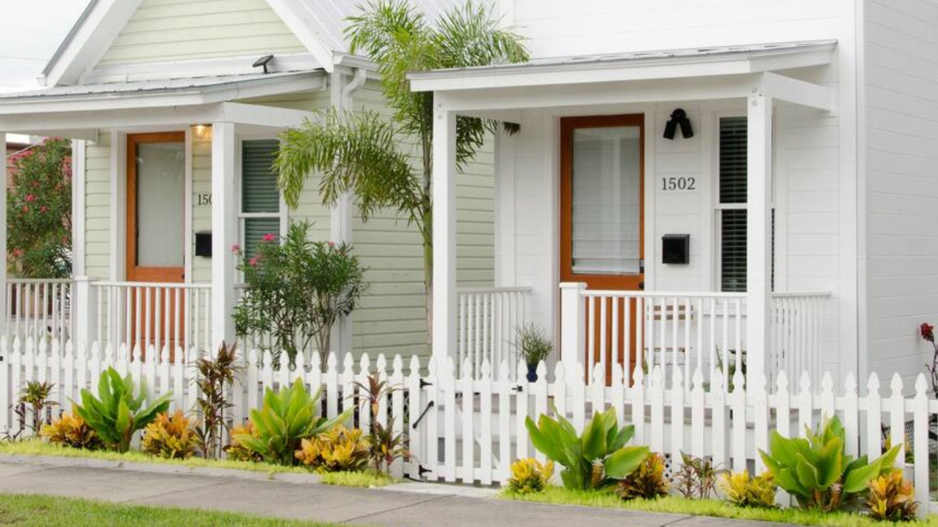 Two white similar houses, next to each other, with small porch