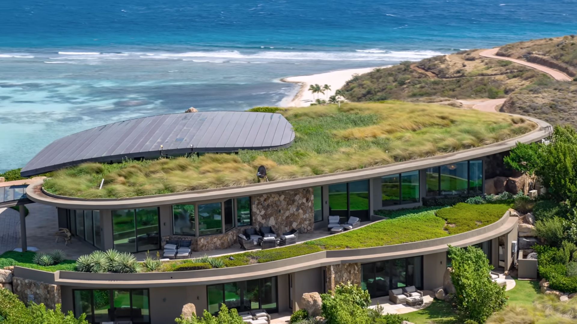 the invisible house surrounded by greenery and the ocean