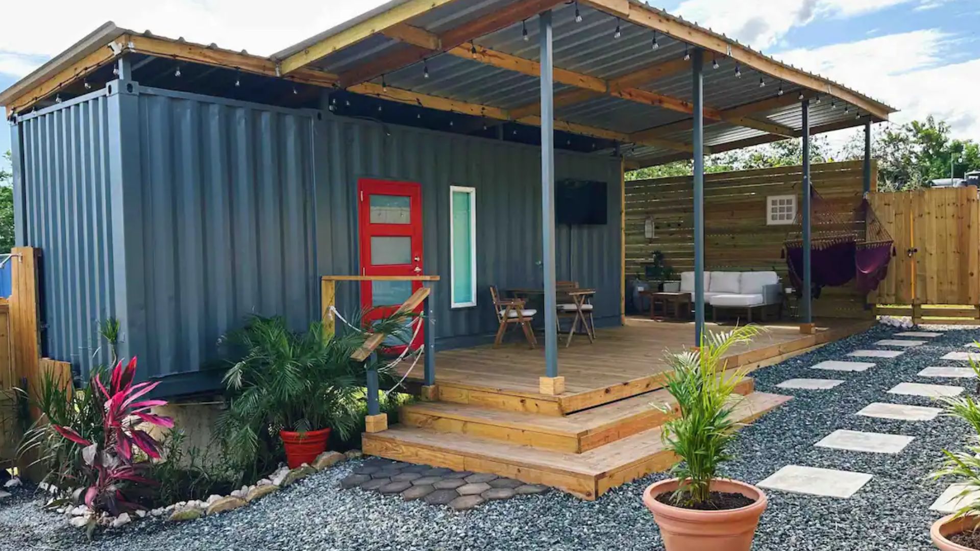 exterior of a container house with a small porch and a yard