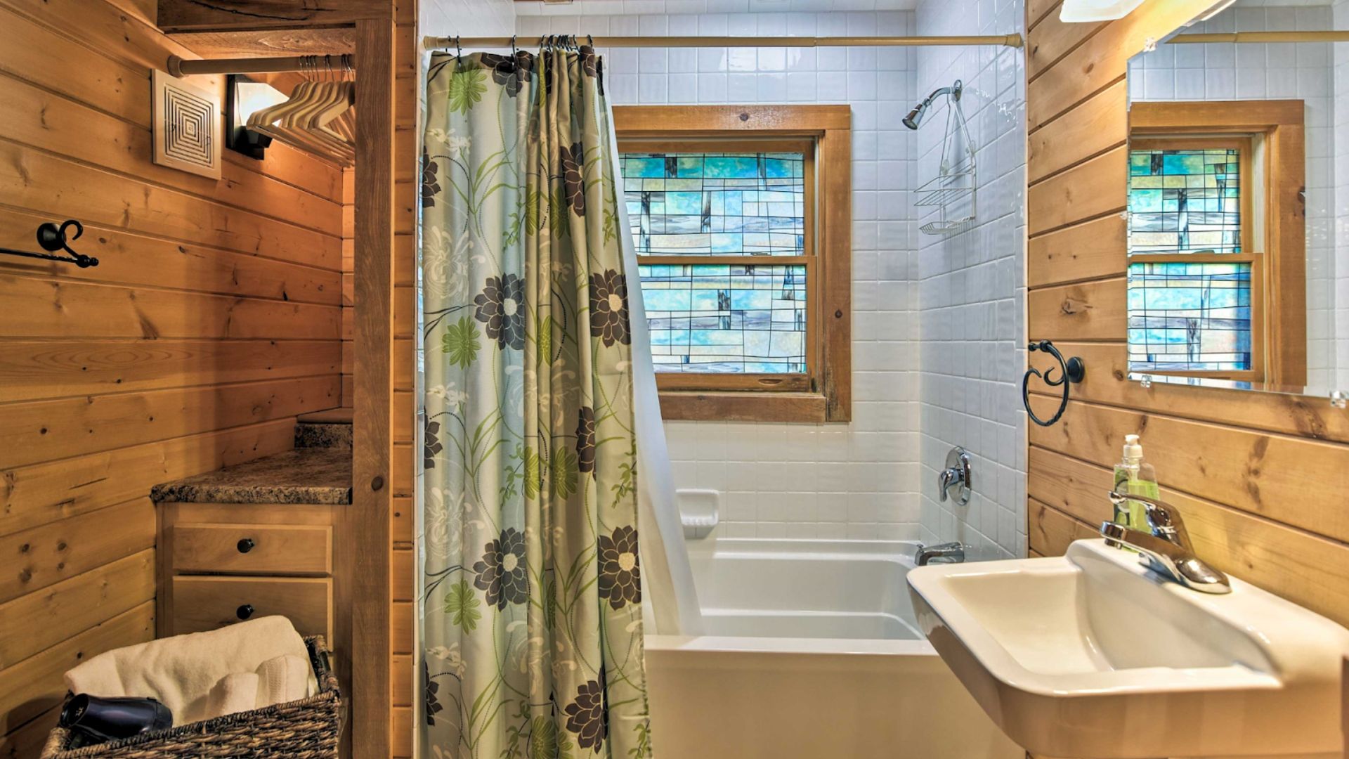 simple bathroom with a bathrub nook and a colorful green shower curtain