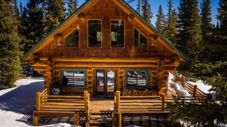 exterior of a log cabin surrounded by snow