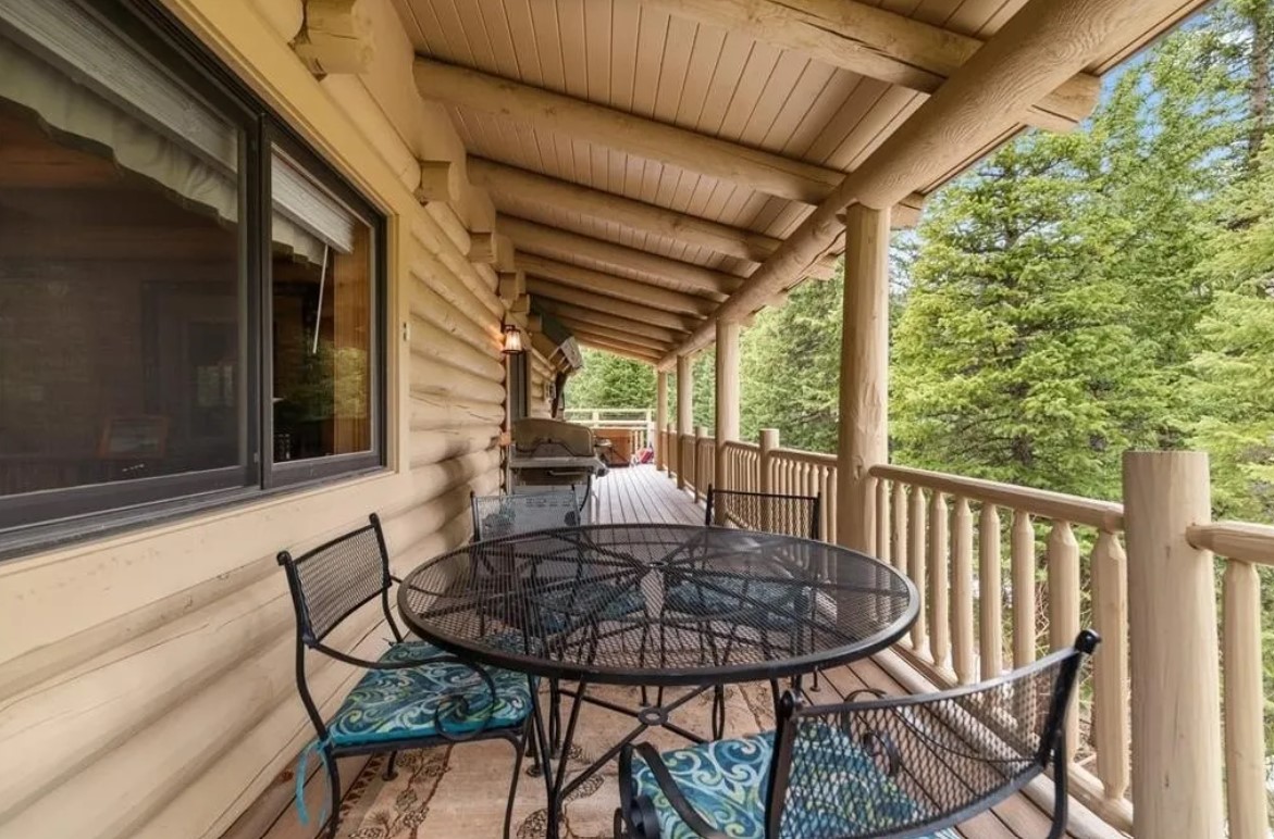 balcony with a table, chairs, grill and a hot tub