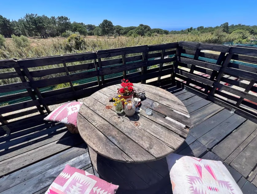 balcony with a round, wooden table and chairs around it