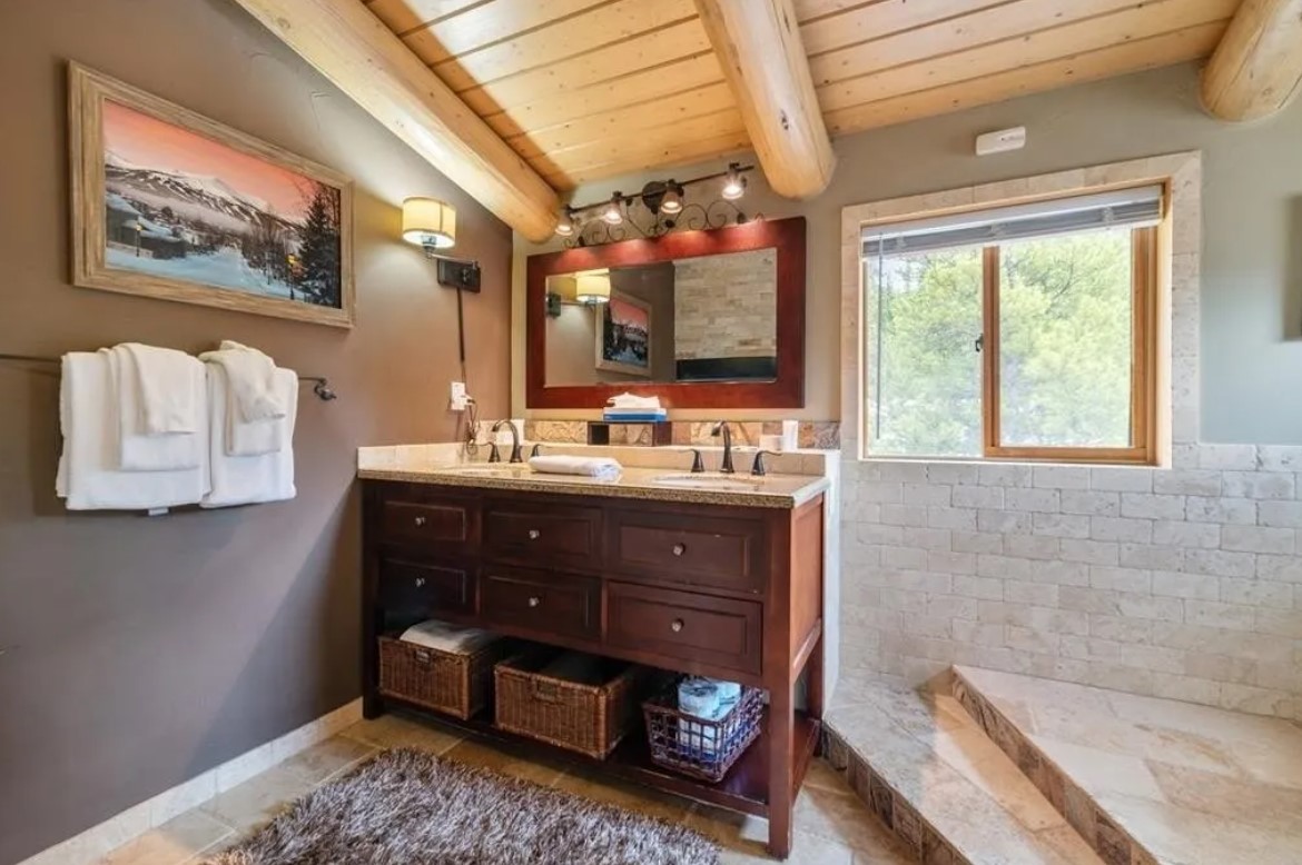 bathroom with a wooden cabinet, mirror above, landscape painting