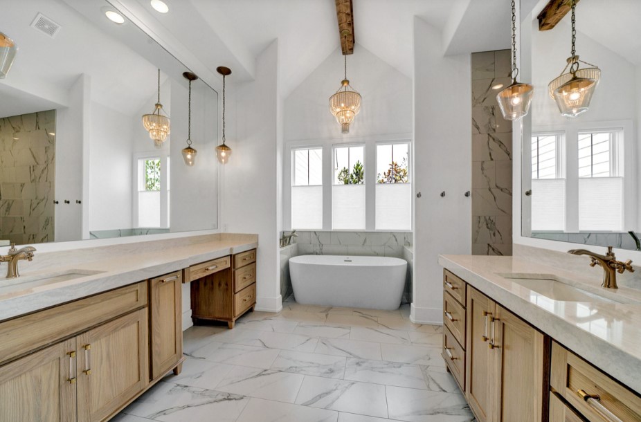 bathroom with a white bathtub, brown cabinets on two sides, stunning chandelier