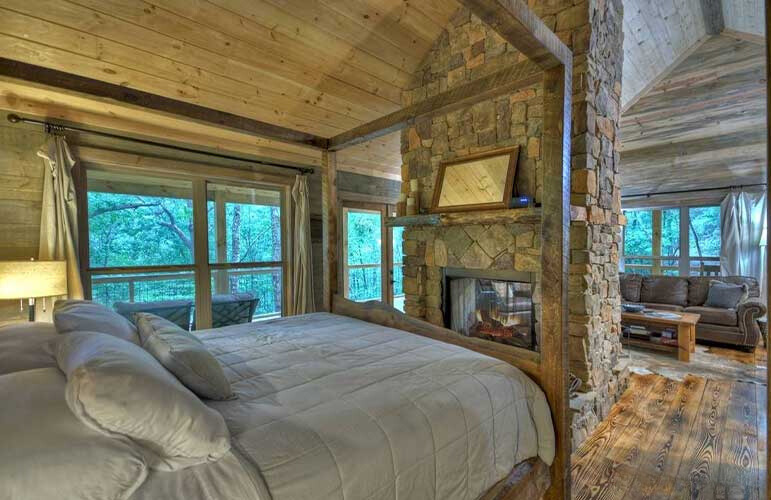 bedroom with a comfy bed, fireplace, glass doors