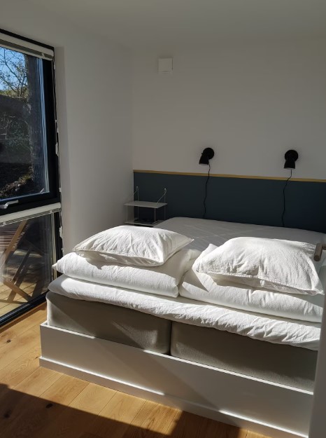 bedroom with a bed with white bed sheets and a big windows