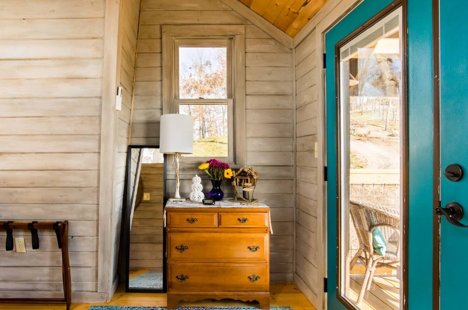 bedroom with a wooden cabinet, narrow mirror, balcony