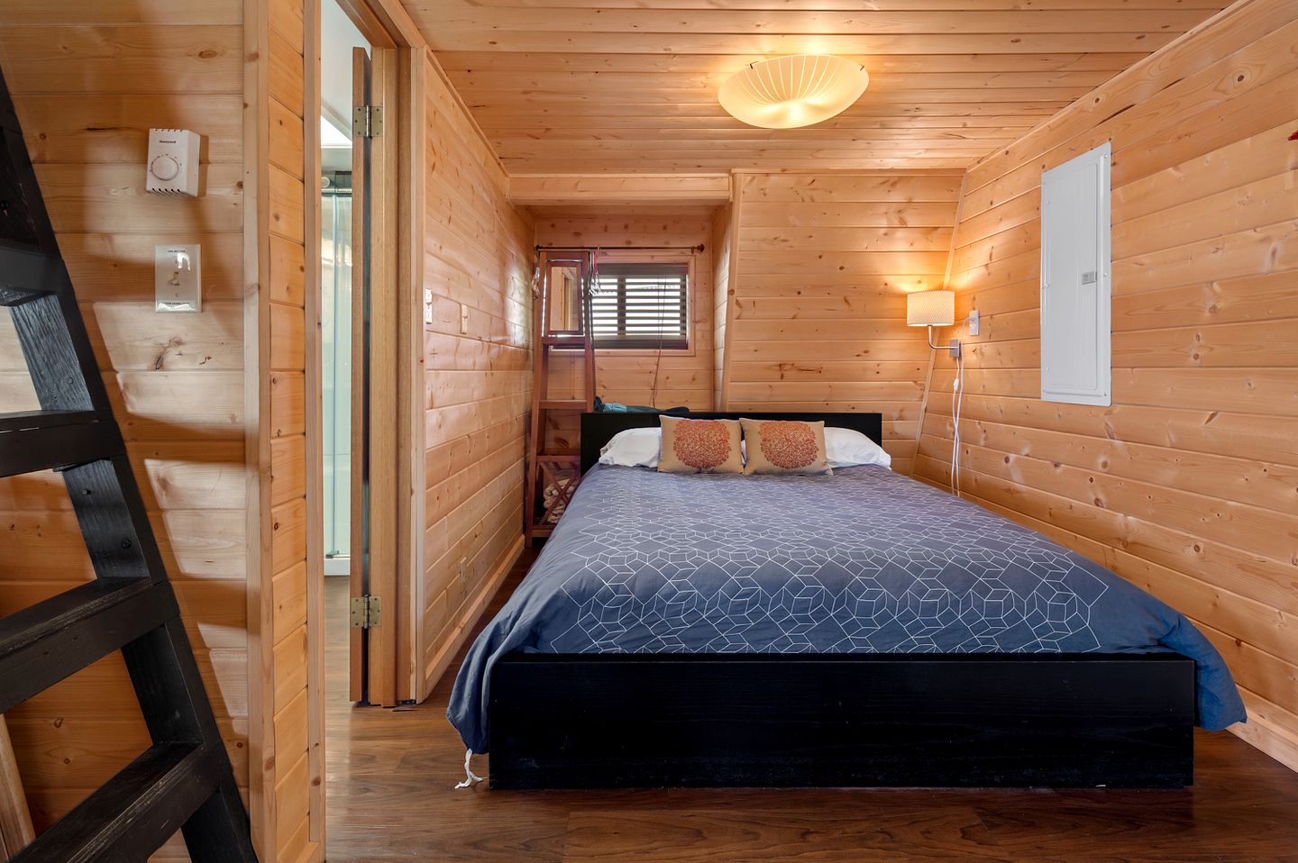 bedroom with wooden walls and a bed