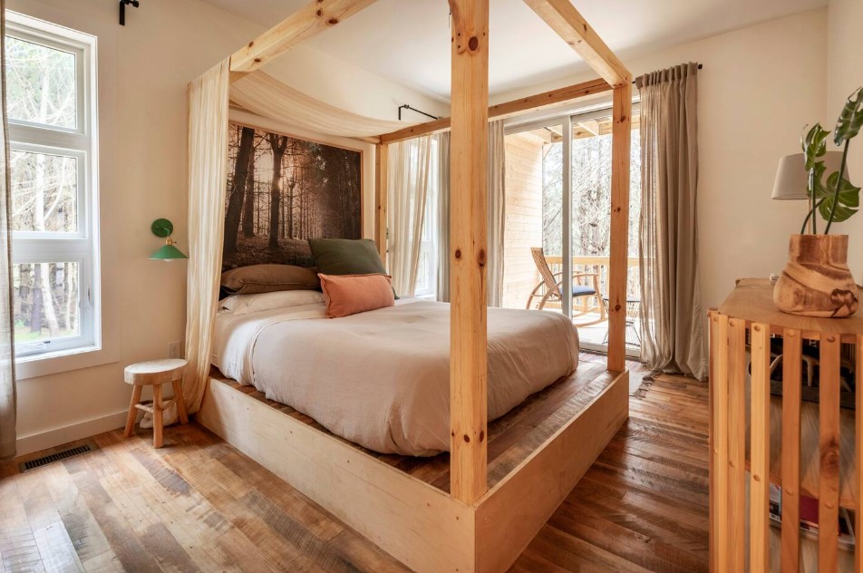 bedroom with a canopy bed, soft curtains, glass doors, tiny bedside table, green lamp