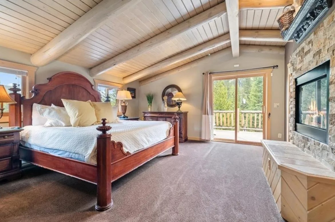 bedroom with a bed with a wooden frame, mounted ceiling, fireplace