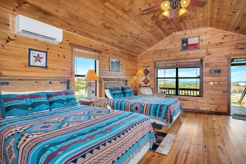 bedroom with twin beds, large windows and wooden walls