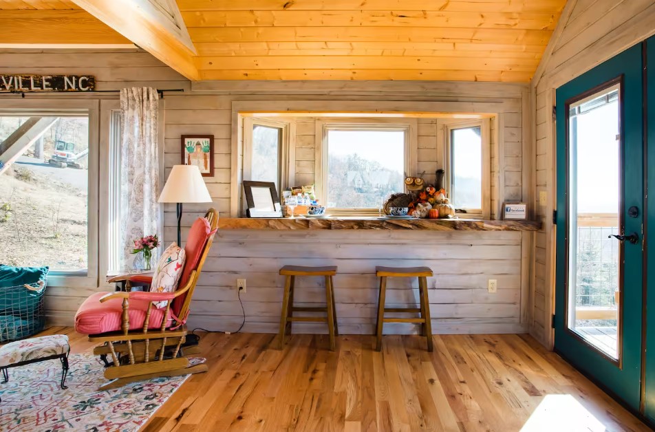 built-in wooden table below the windows and two wooden stools