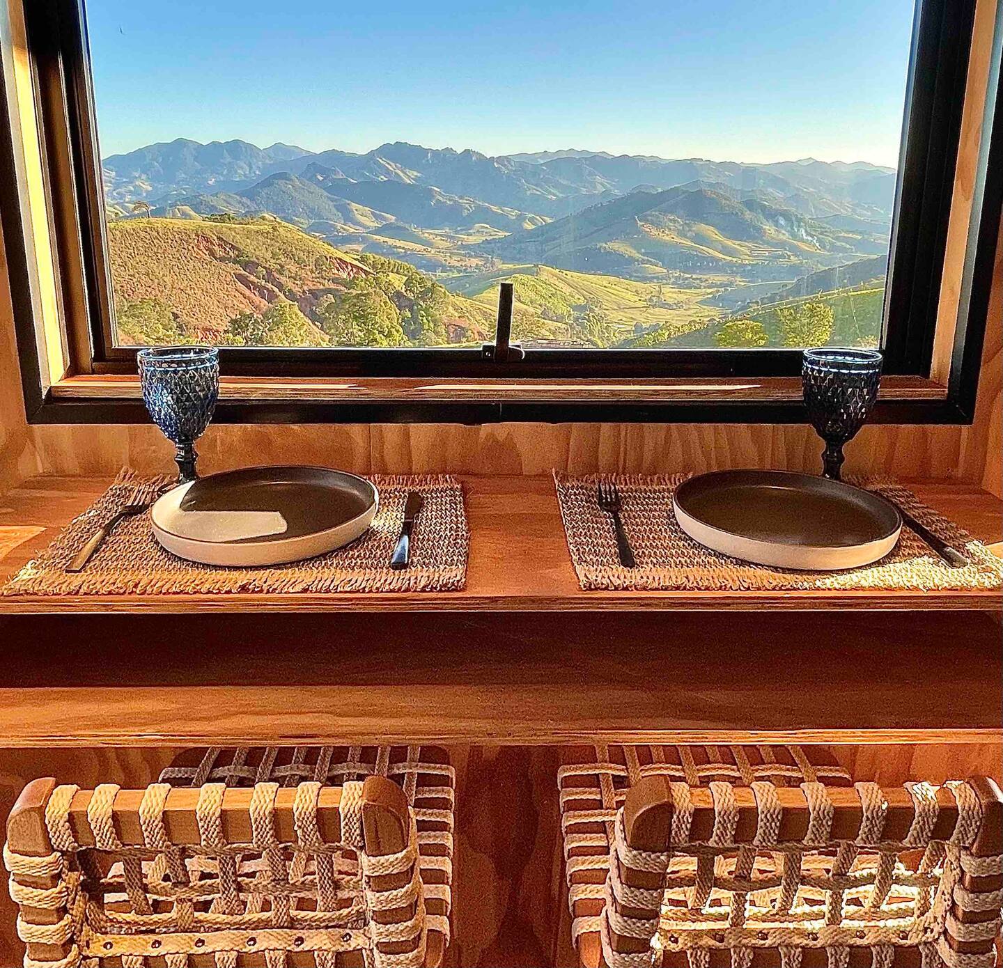 dining area with a bar and a window in front, two plates and glasses already served