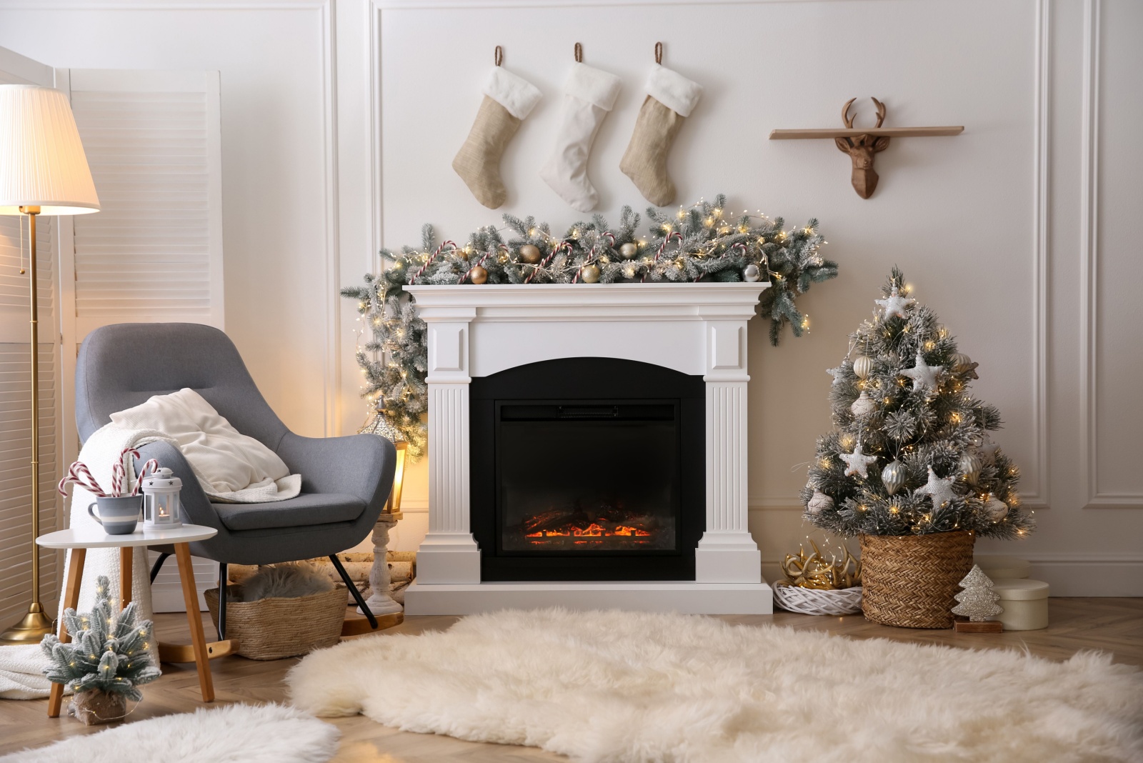 living room with a fireplace, blue chair and christmas decor in silver and beige colors