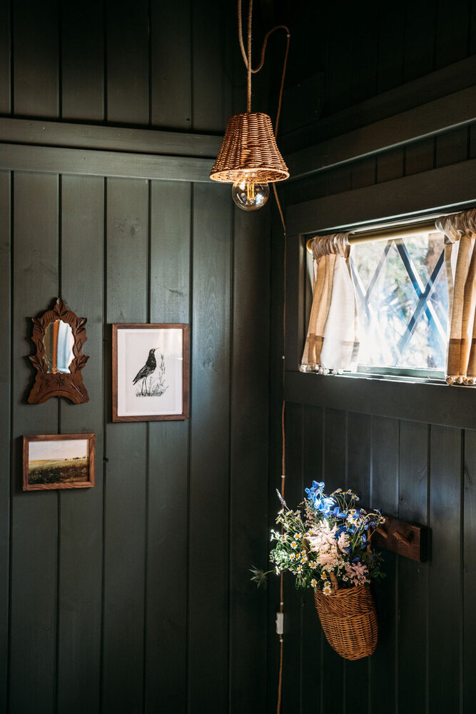 framed photos of a bird and land, mini framed mirror, mini window with small curtains, colorful flowers