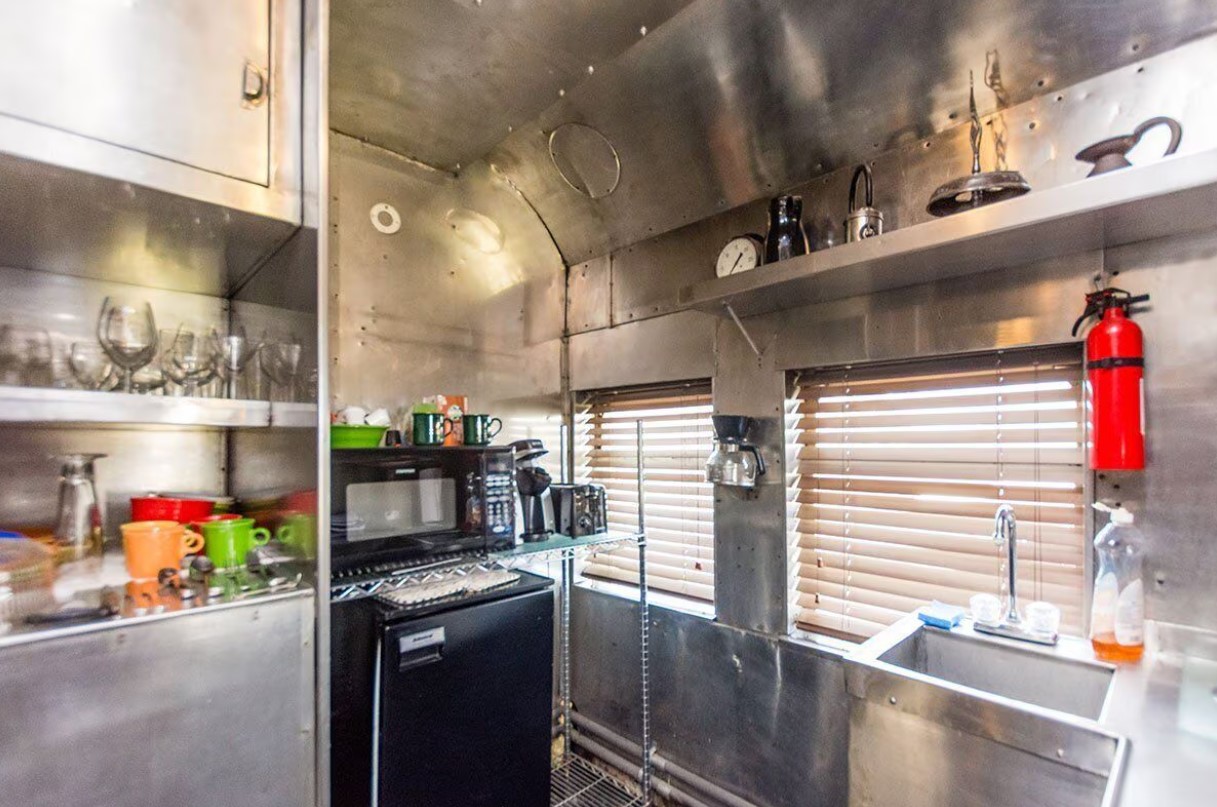 kitchen with open shelves and a black fridge