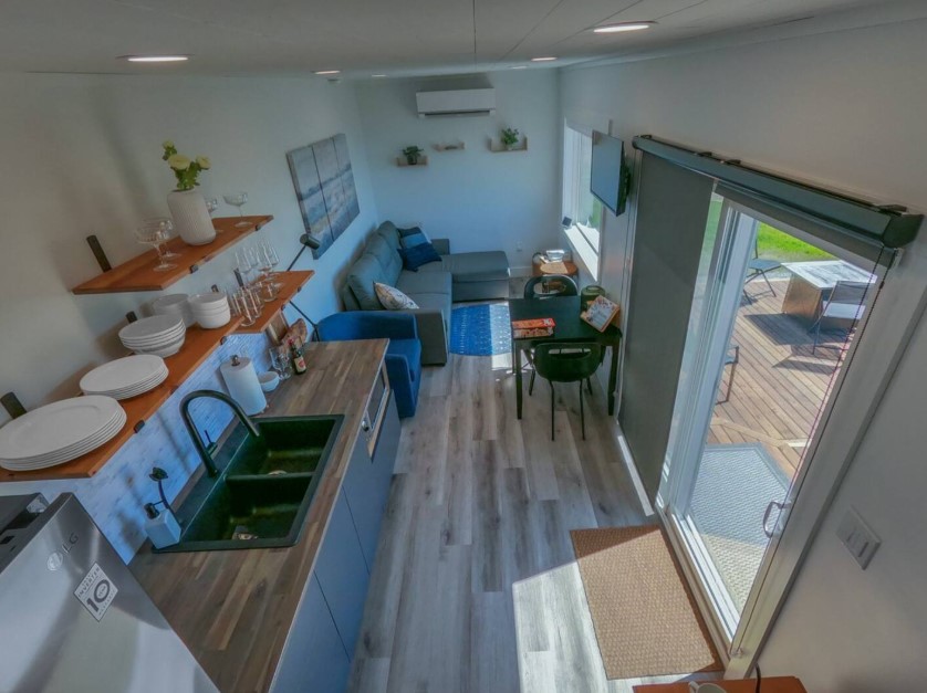 kitchen with open shelves, wooden countertop, glass doors, living room in the back