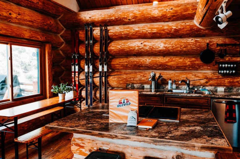 kitchen with log walls, granite countertop island, skis on the wall