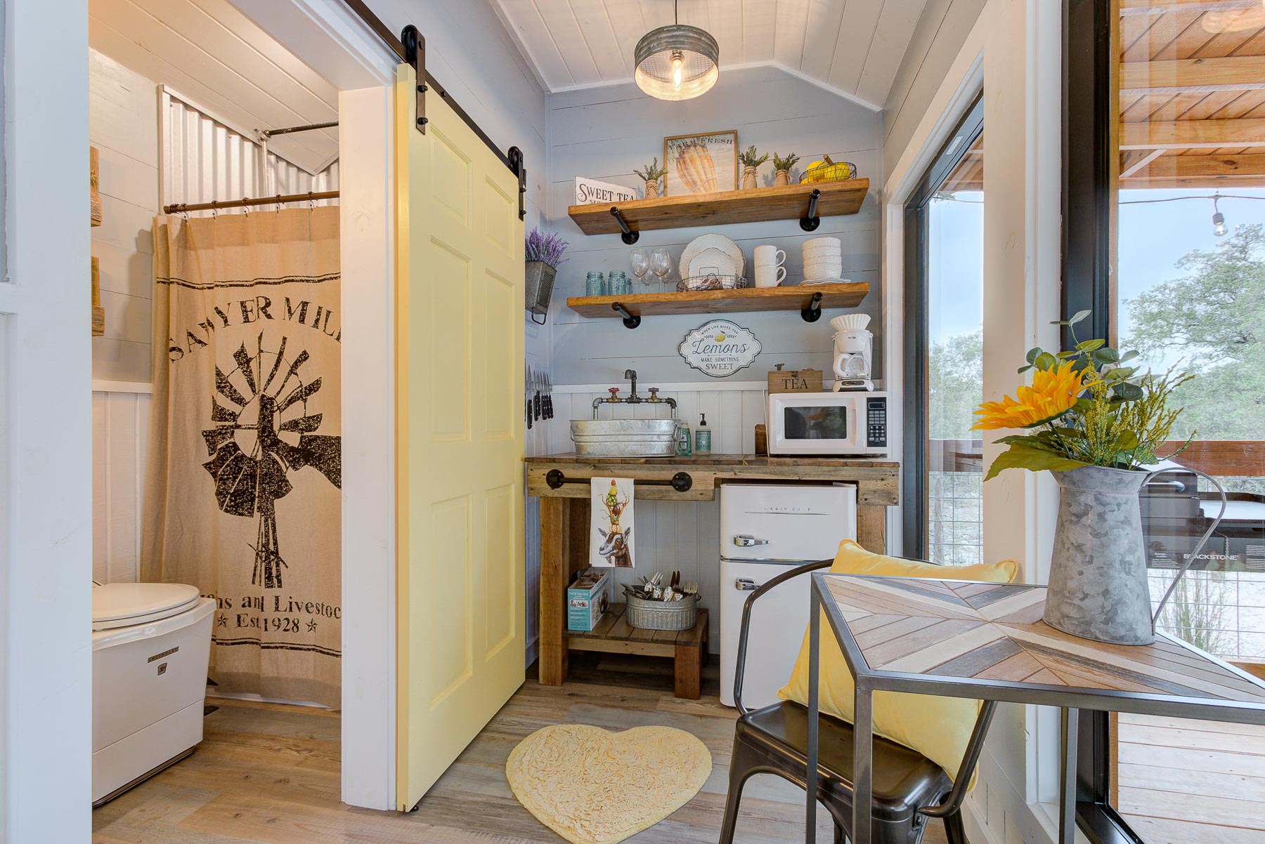 kitchen with open wooden shelves, wooden countertop, dining table next to glass doors, yellow heart rug