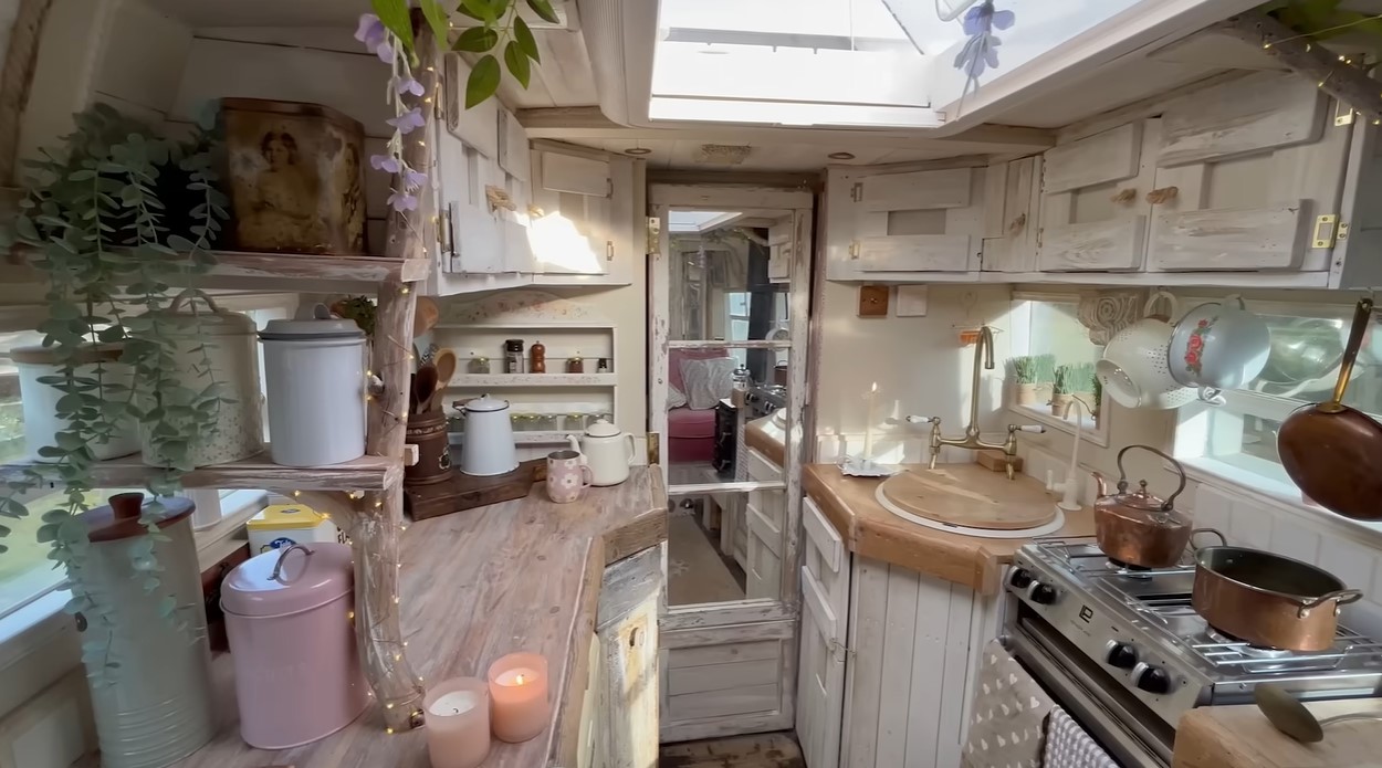 kitchen with light brown countertops, white cabinets, candles and plants