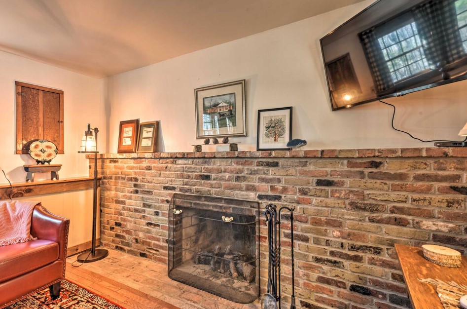 living area with a flat screen tv, dark red chair fireplace, vintage decor and frames