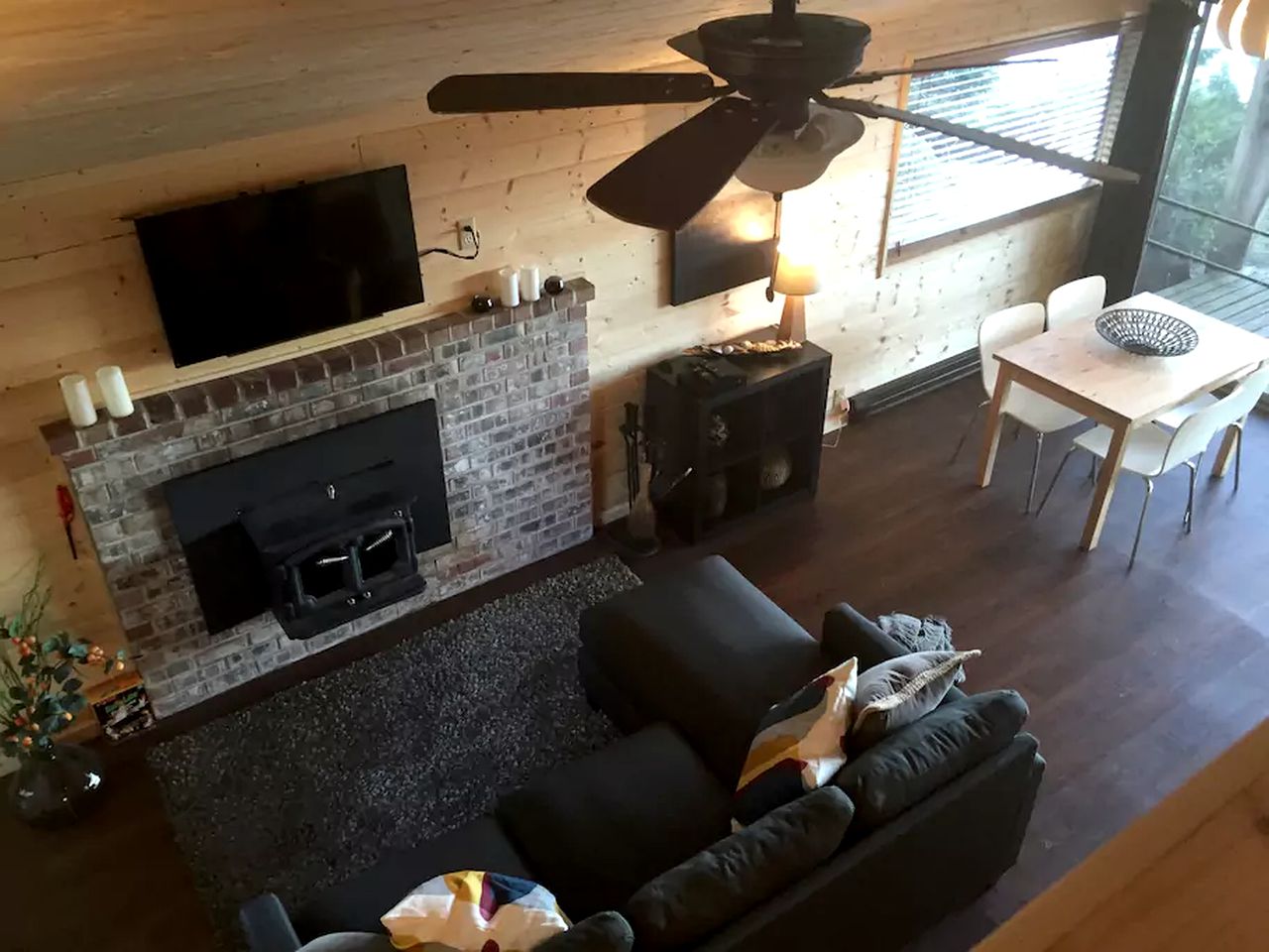 living room with a black l-shaped couch, flat screen tv, fireplace