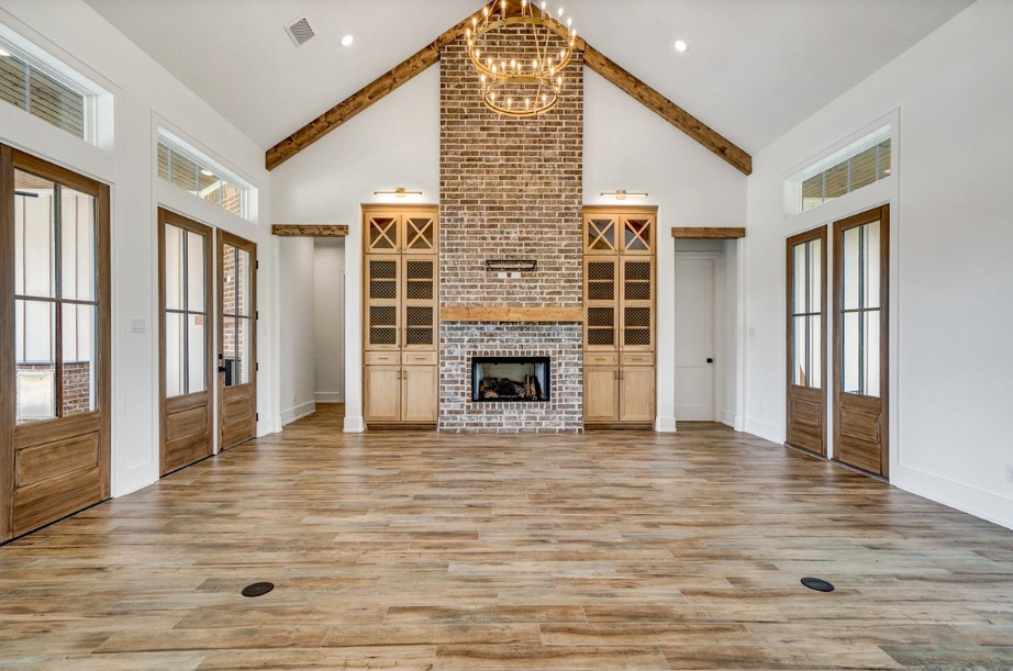 empty living room with a fireplace, chandelier on top