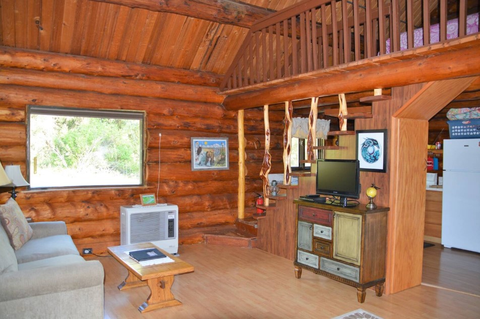 living room with a tv, cabinet with mismatched drawers, gray couch, tiny wooden table