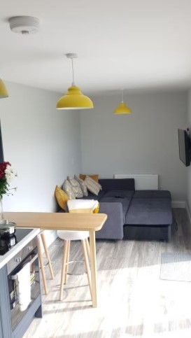 living room with a dark gray couch that's pulled out and yellow lamps