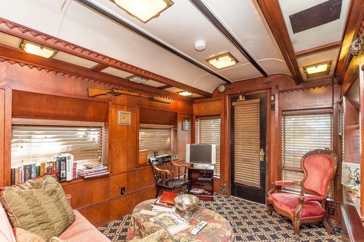 living room with a vintage red chair, windows which are also shelves, small tv