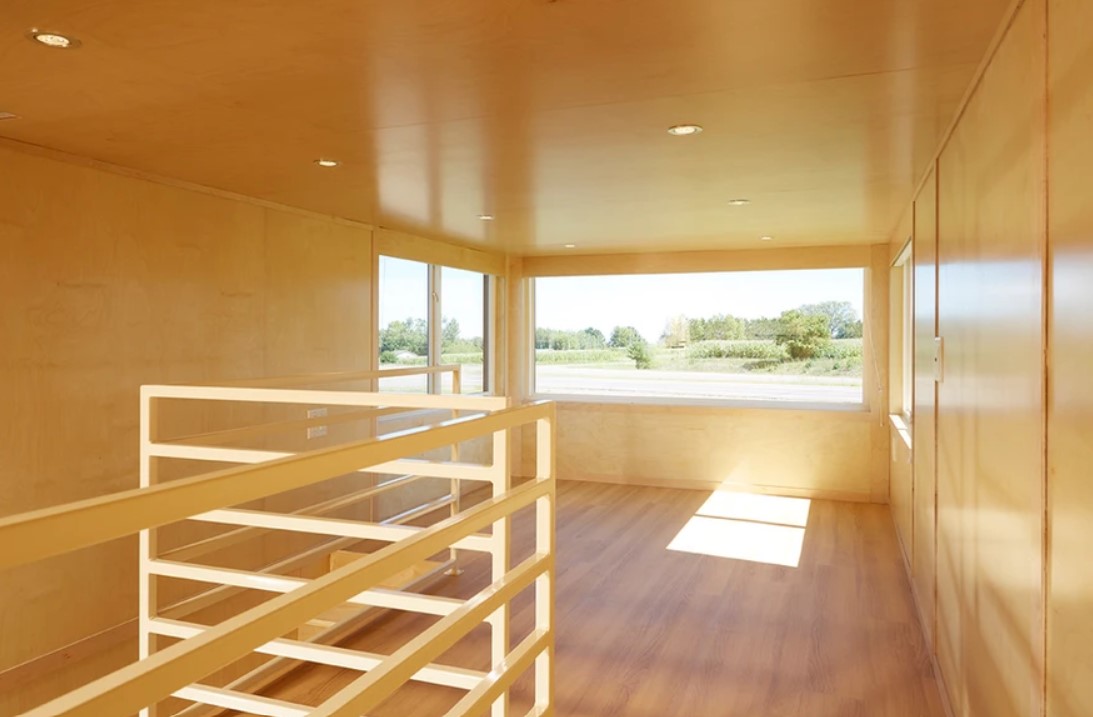 empty loft bedroom with large windows and light brown walls