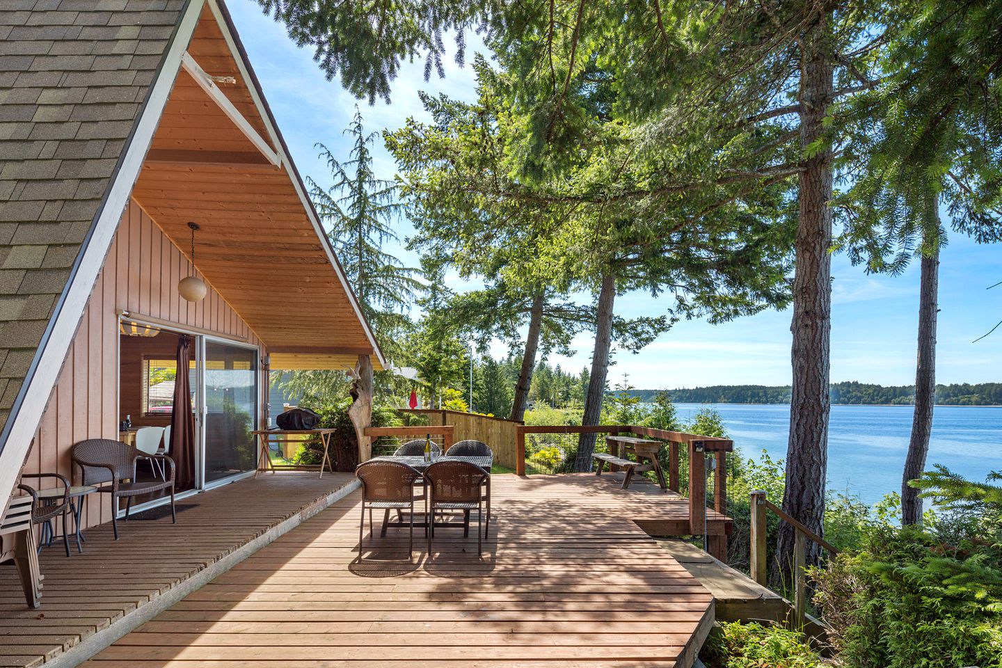 patio of a cabin with a dining table, ocean nearby