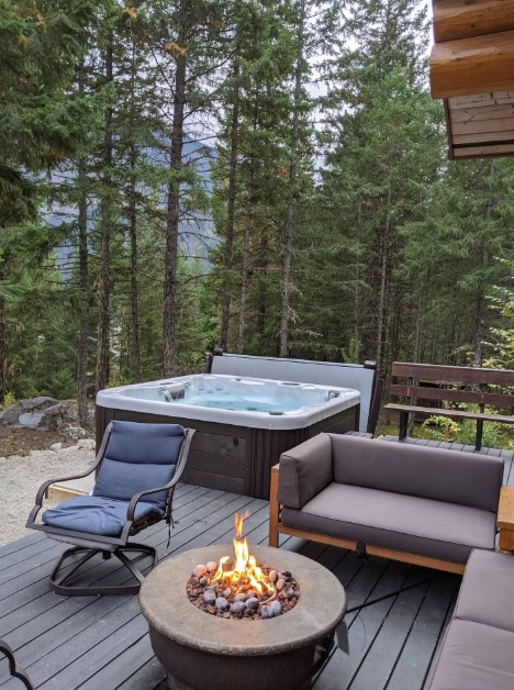 patio with a hot tub, fire pit and furnished sitting area