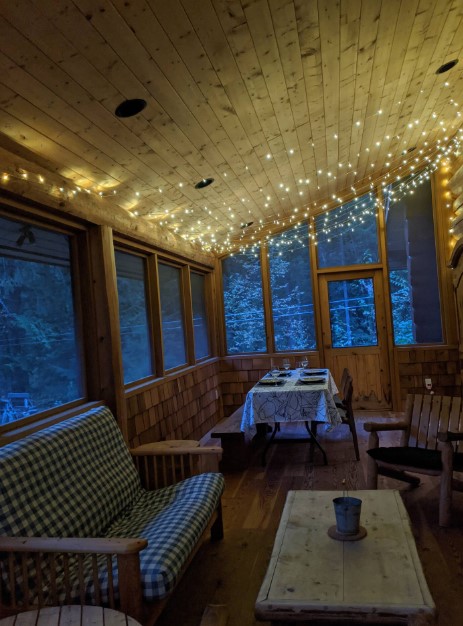 room with a dining table, smaller table, fairy light on the ceiling