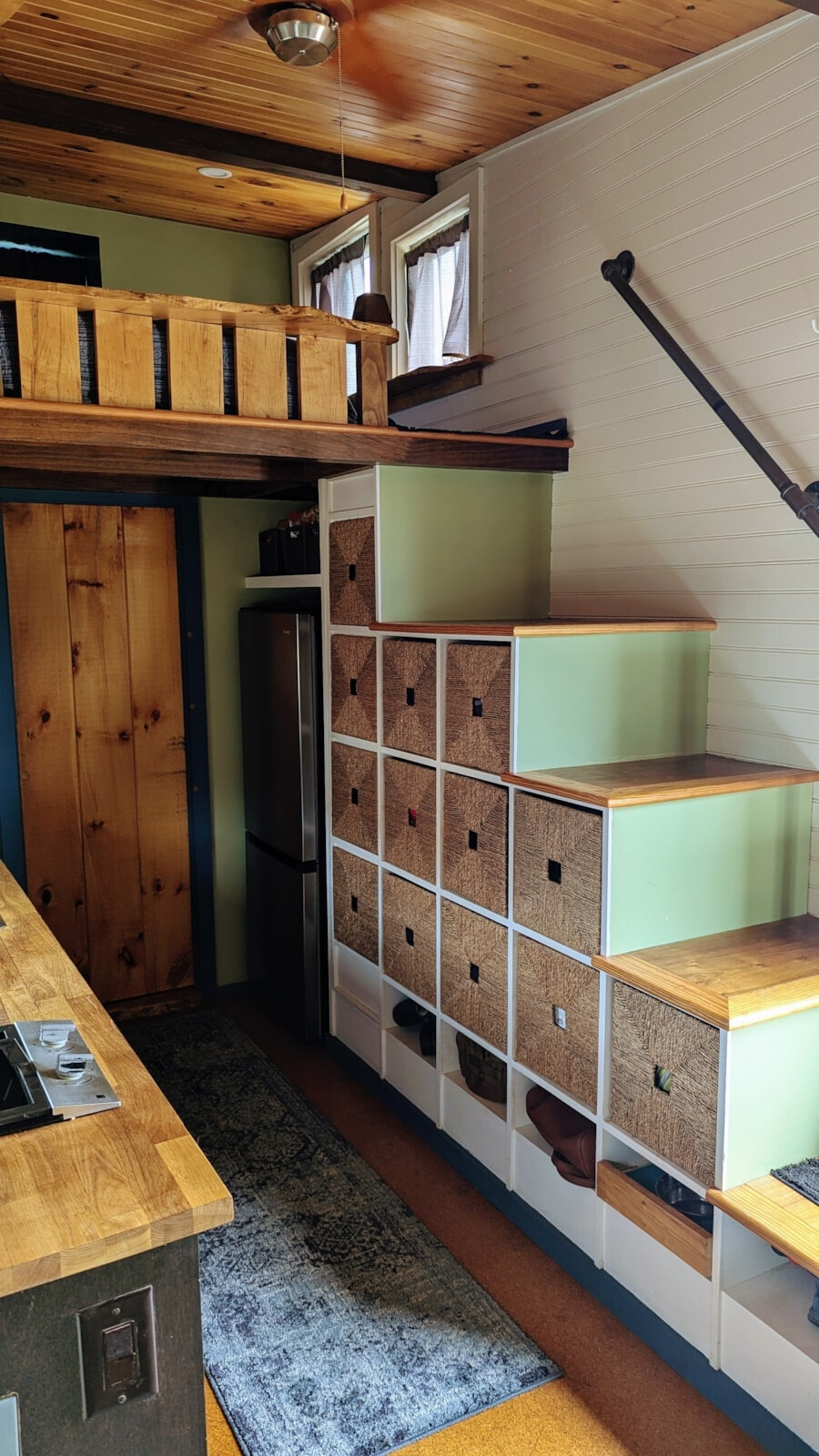 staircase in the kitchen leading to the loft that's doubling as storage