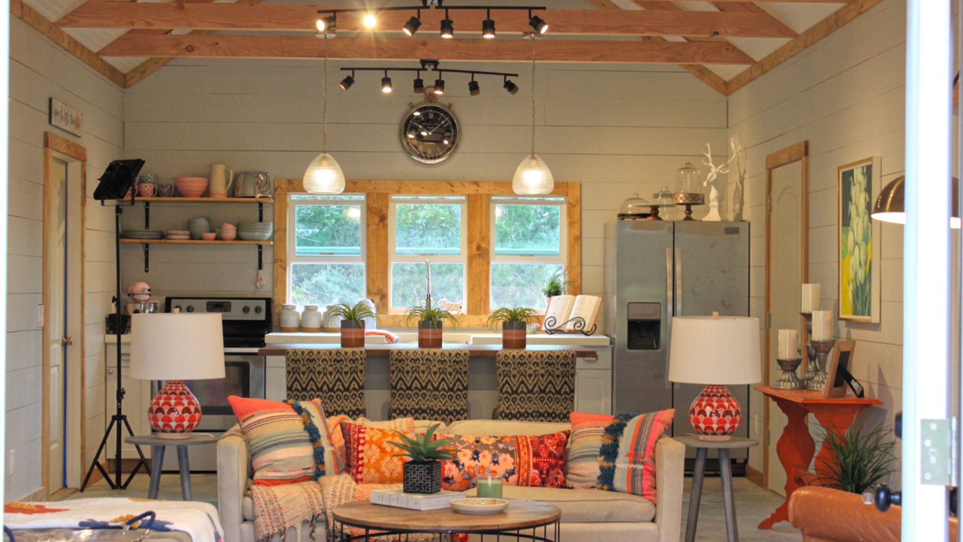 cozy and colorful living room with a kitchen in the back